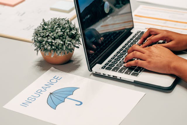 insurance paperwork beside laptop workspace